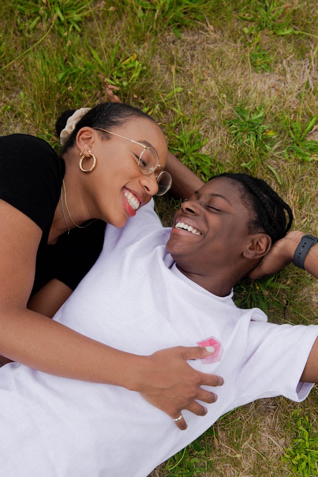 black queer couple laughs in the grass