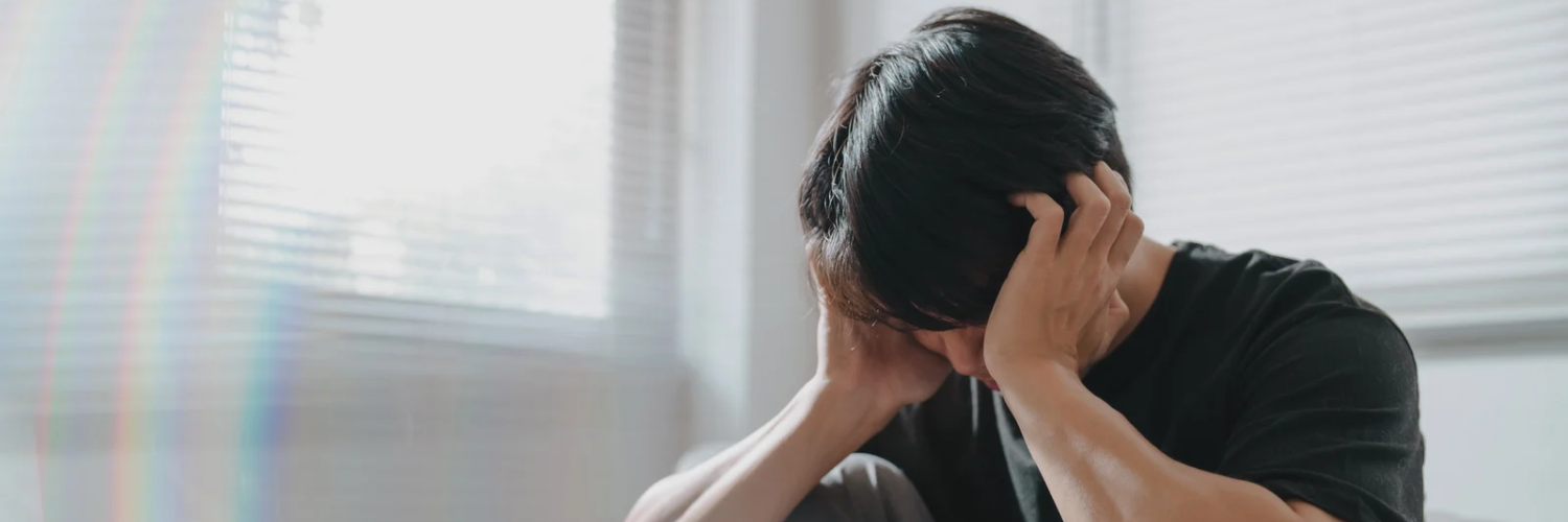 an image of a man holding his head in his hands to signify anxiety